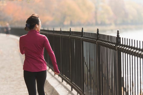 asian woman running on waterfront path