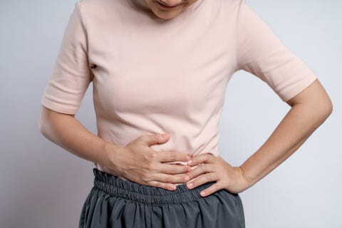 asian woman was sick with stomach ache standing isolated on white background