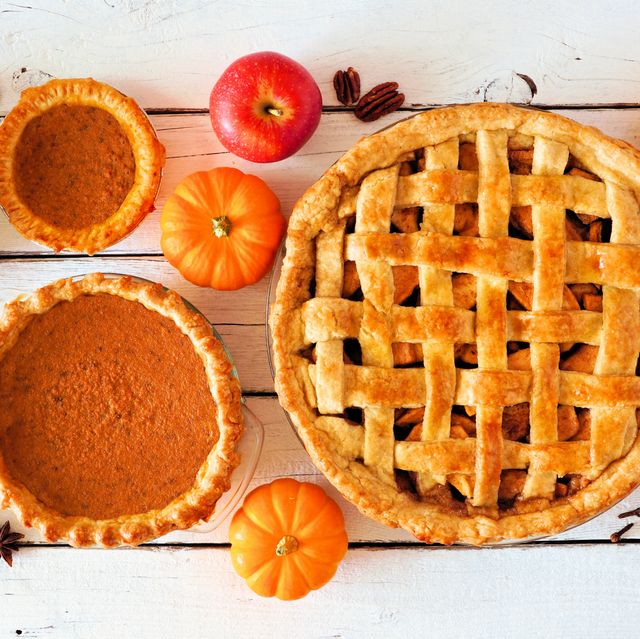 assorted homemade autumn pies table scene on a white wood background