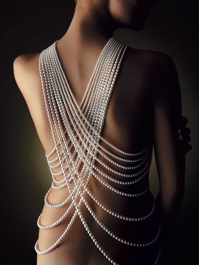 a girl's bare back covered in pearls