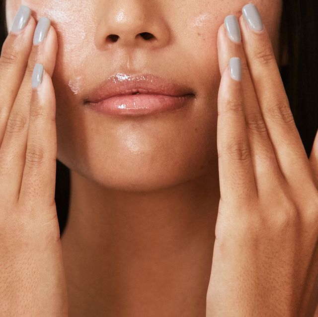 woman applying skincare product to face