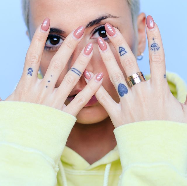 woman with tattooed hands showing off manicure