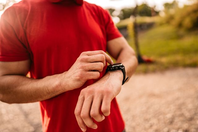 athlete check fitness tracker after training in nature