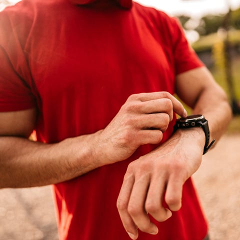 Athlete check fitness tracker after training in nature