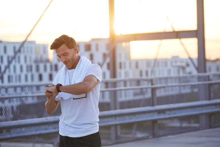 Athlete in the city looking on smartwatch