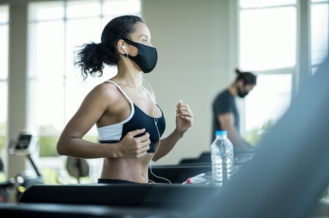 athlete workout exercise at gym after pandemic reopening they are running on treadmill and wearing protect facemask during virus protection