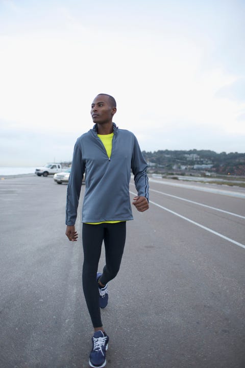 athletic black man walking along road