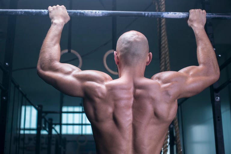 Athletic man exercising chin-ups in a health club