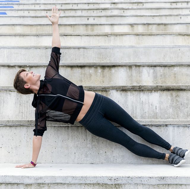 athletic woman during workout on stairs, side plank