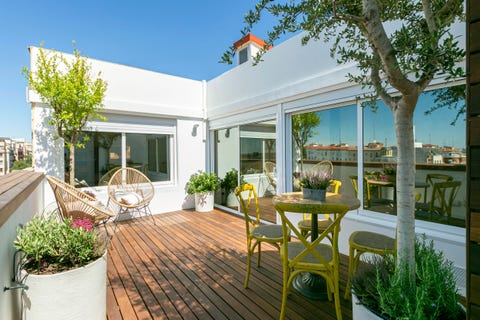 terraza con tarima de madera, comedor vintage y sillas acapulco