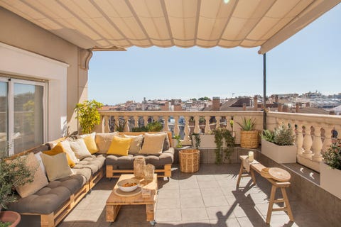 terraza con sofá de palés y toldo