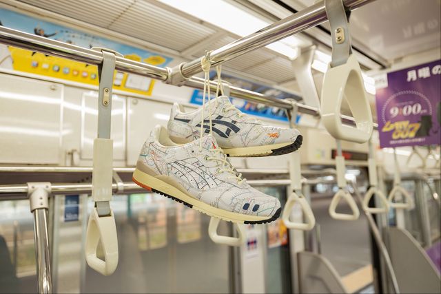 asics sneakers hanging from a rail inside a tokyo subway car