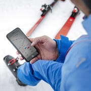 ski apps a skier looking at his phone