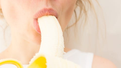 Attracting young lady chewing banana