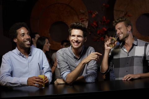 Cheerful friends enjoying drinks in nightclub
