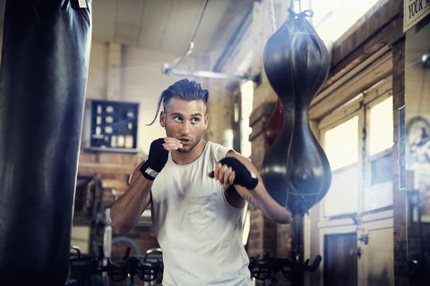 Hispanic man punching speed bag in gymnasium