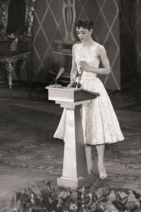 original caption 3251954 new york  audrey hepburn smiles sweetly as she receives hollywood's highest accolade  an oscar for the best performance by an actress  from jean hersholt at the center theater tonight the 22 year old stage and screen star won her award for her only american film, "roman holiday"