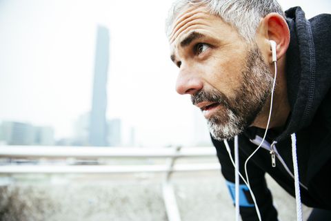 Austria, Vienna, exhausted athlete wearing earphones