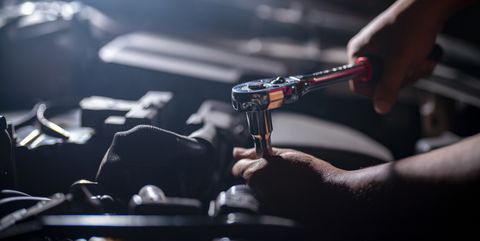 auto mechanic working on car engine in mechanics garage repair service authentic close up shot