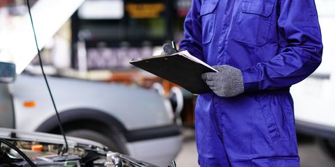 automotive mechanic doing vehicle maintenance checklist