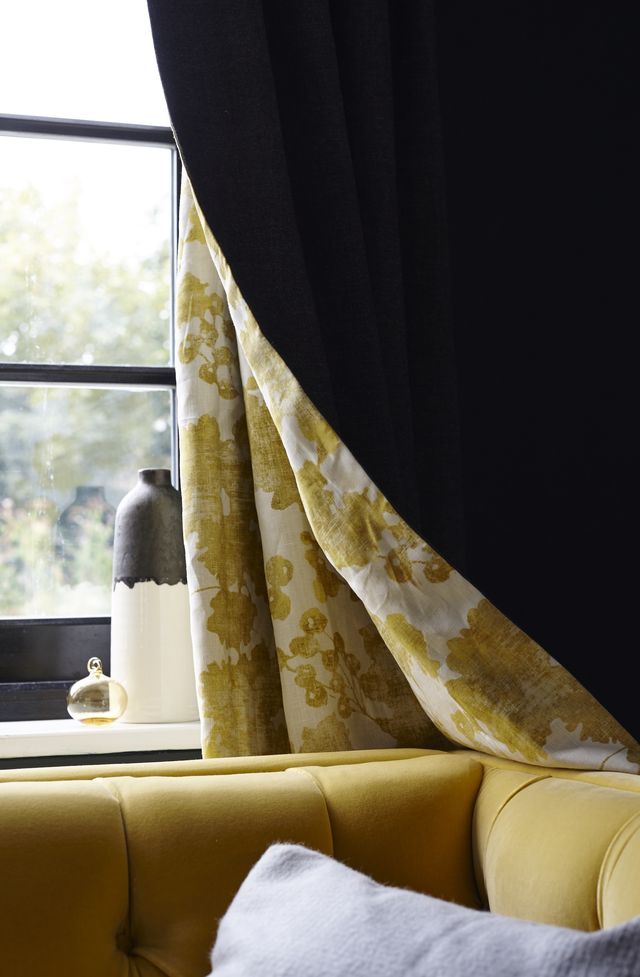 秋の色合い - イエローのソファにかけられたリビングのカーテン
