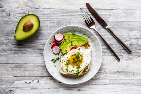 Toast with with fried egg, avocado, red radish, tomato and cress