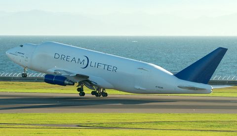 boeing 747 dreamlifter taking off next to the ocean