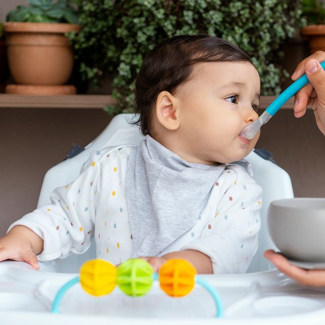 parent feeding baby cereal with spoon