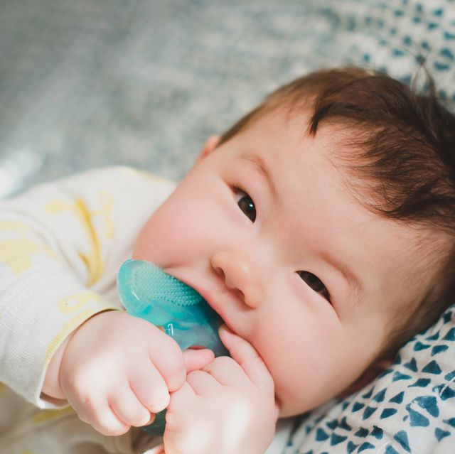 baby chewing on blue teether