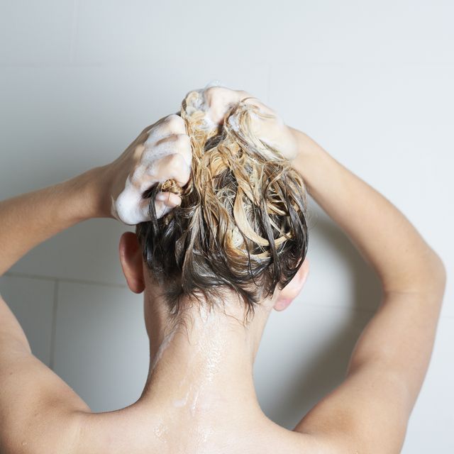 mujer rubia lavándose el cabello