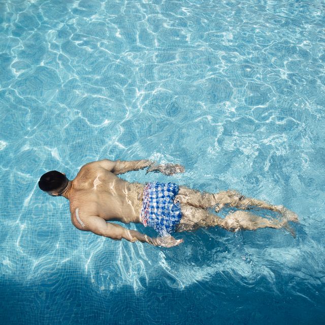 back view of man floating in swimming pool