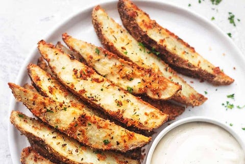 baked garlic potato wedges op een wit bord