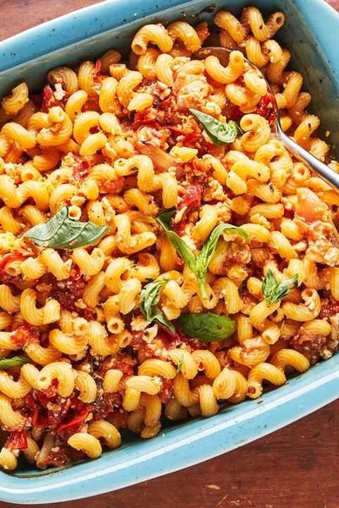 baked feta pasta with tomatoes and basil in a blue baking dish
