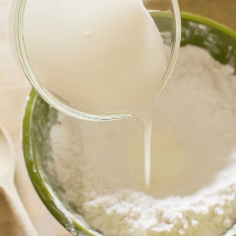 pouring milk into bowl with flour