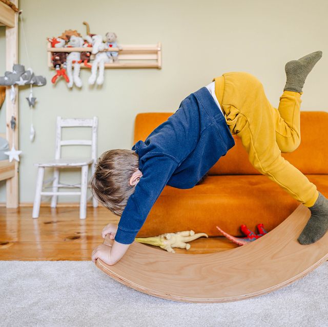 kid playing with balance board in play room
