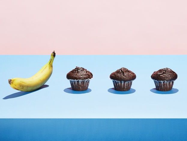 A banana in a row of chocolate cupcakes
