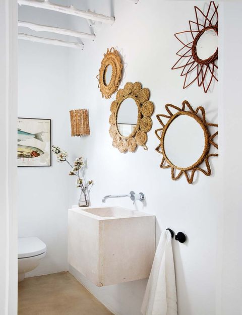 baño con lavabo de microcemento y espejos artesanales