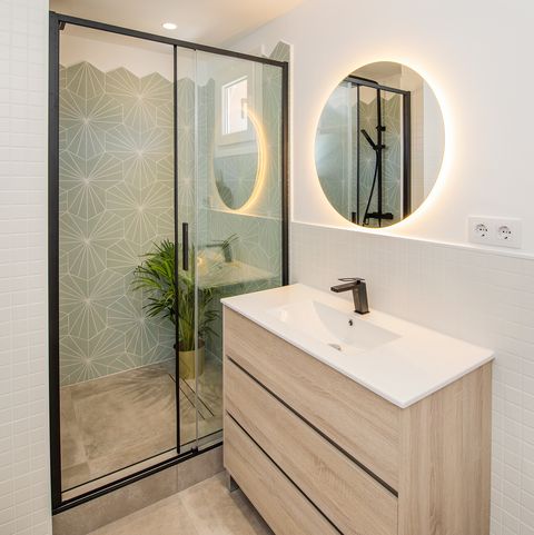 baño moderno con ducha y azulejos geométricos verdes