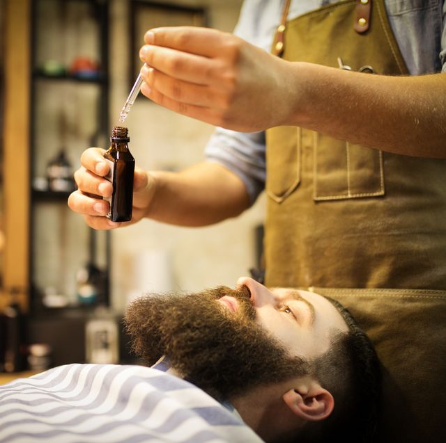 barber putting beard oil to client