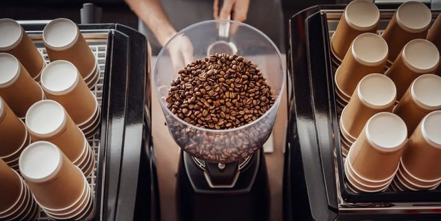 barista operating grinder with coffee beans