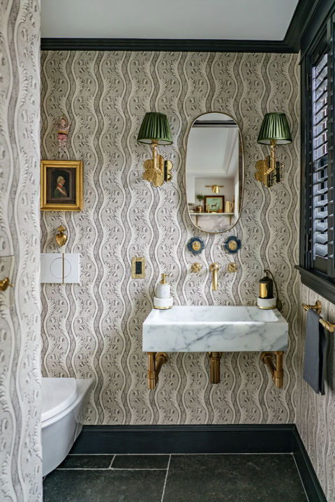 bathroom with green and gold sconces