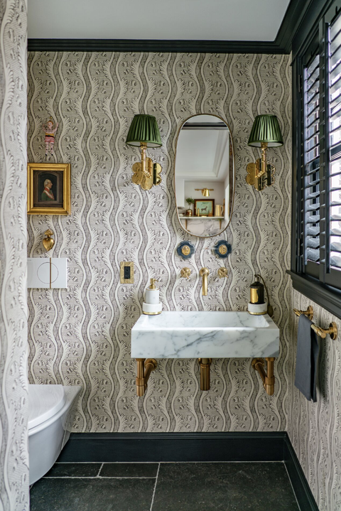 bathroom with green and gold sconces