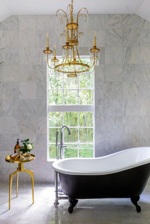 bathroom with freestanding tub and gold chandelier