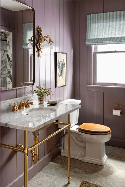 small bathroom in a mauve paint color with gold embellishments