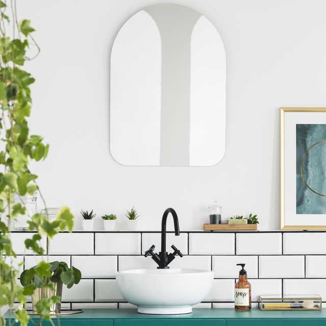 mirror and poster in white bathroom interior with washbasin and plant
