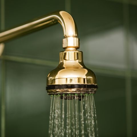 metallic gold bathroom shower head and running water