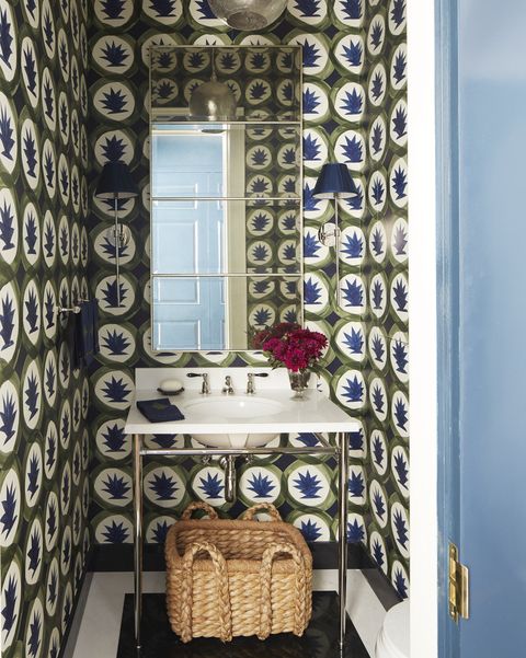 statement making hermes wallpaper adds a fun flair to the simple vintage sink along with a tall mirror by made goods and sconces by the urban electric co