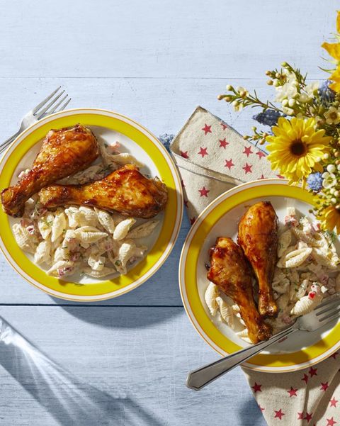 barbecue chicken drumsticks on yellow plate with macaroni salad