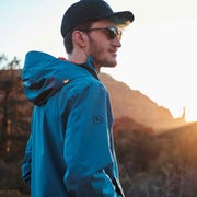 man wearing backcountry jacket looking into the distance as the sun sets