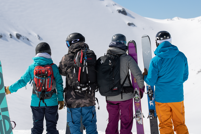 snowboarders on snowy mountain with backcountry gear